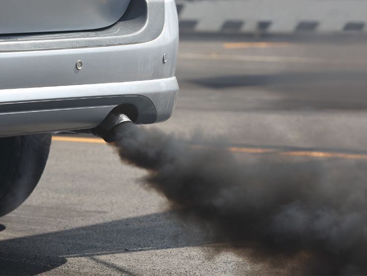 auto con fumo nero che esce dal tubo di scappamento