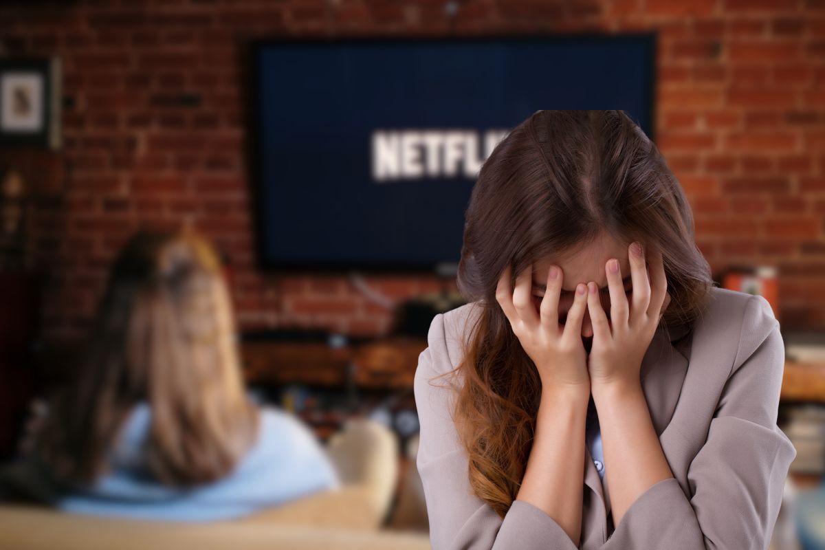 donna che guarda netflix sul divano e un'altra dispiaciuta