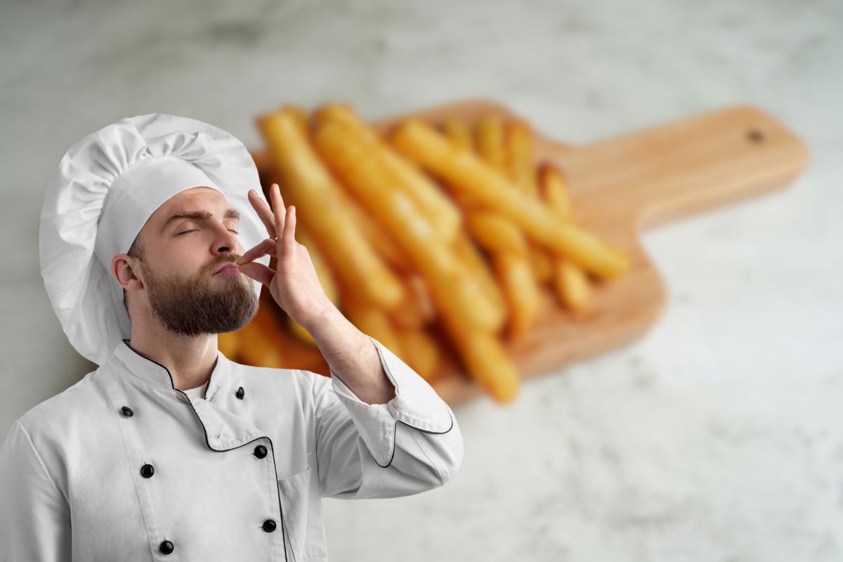 patatine fritte su tagliere di legno e chef 