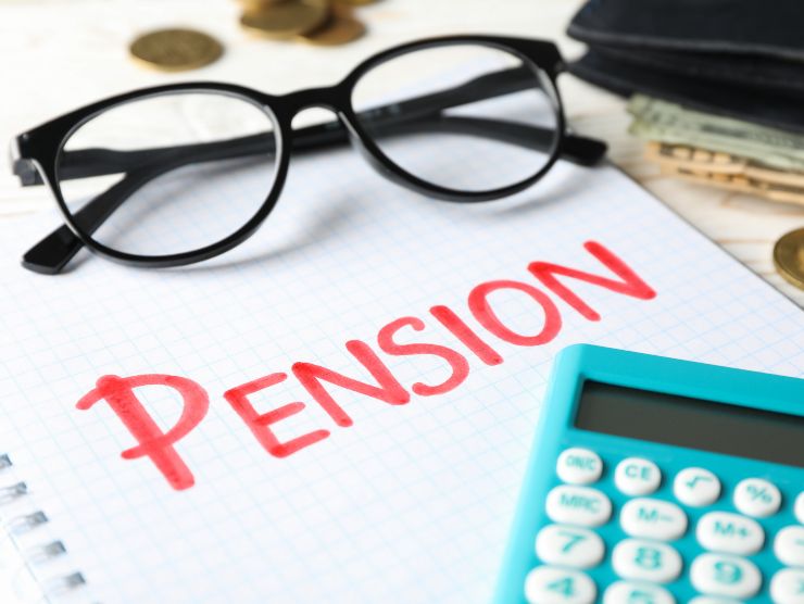 calcolatrice e foglio con scritta pensione su tavolo