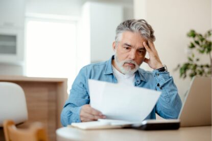 uomo preoccupato che legge documenti
